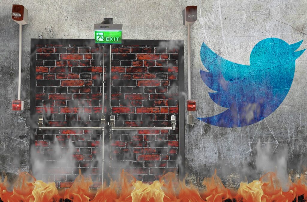 A dirty, cracked wall with a bricked-up fire-exit set into it - a pair of double-doors with crashbars, fire alarms, and a fire exit sign. To the left of the doors is a faded, dirty Twitter logo. The bottom of the frame is filled with flames, and smoke rises off of them.
