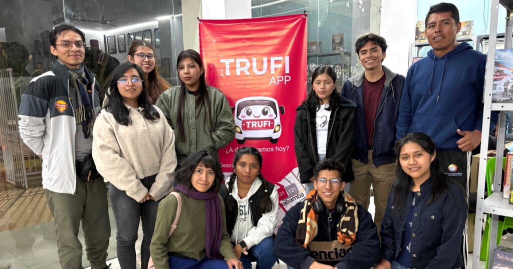 Trufi App volunteers in Cochabamba posing in front of a re Trufi App banner.